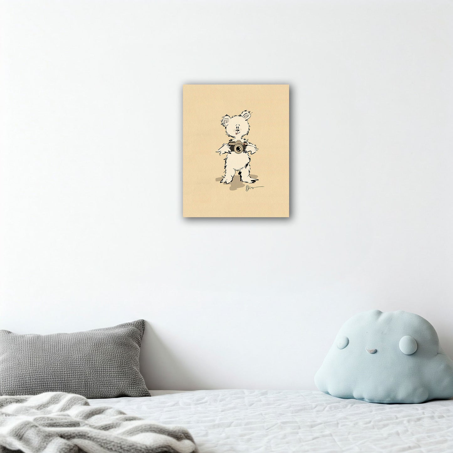 The Gopher Pola Bear print adds a touch of whimsical art to a serene and minimalist child's bedroom. The canvas is shown hanging above a bed with modern grey and light blue pillows."