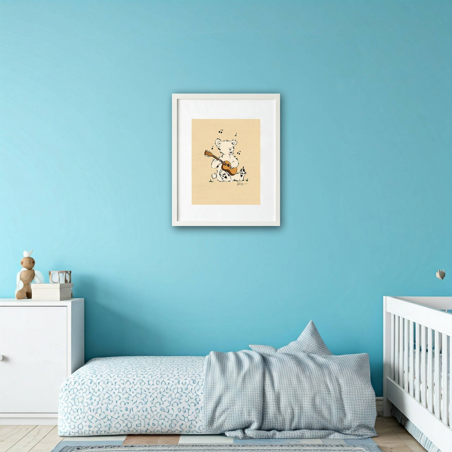 Framed 'Ritchie' the Acoustic Pola Bear art print hanging on a bright blue wall in a cozy nursery or child's bedroom, perfect for music-themed decor.