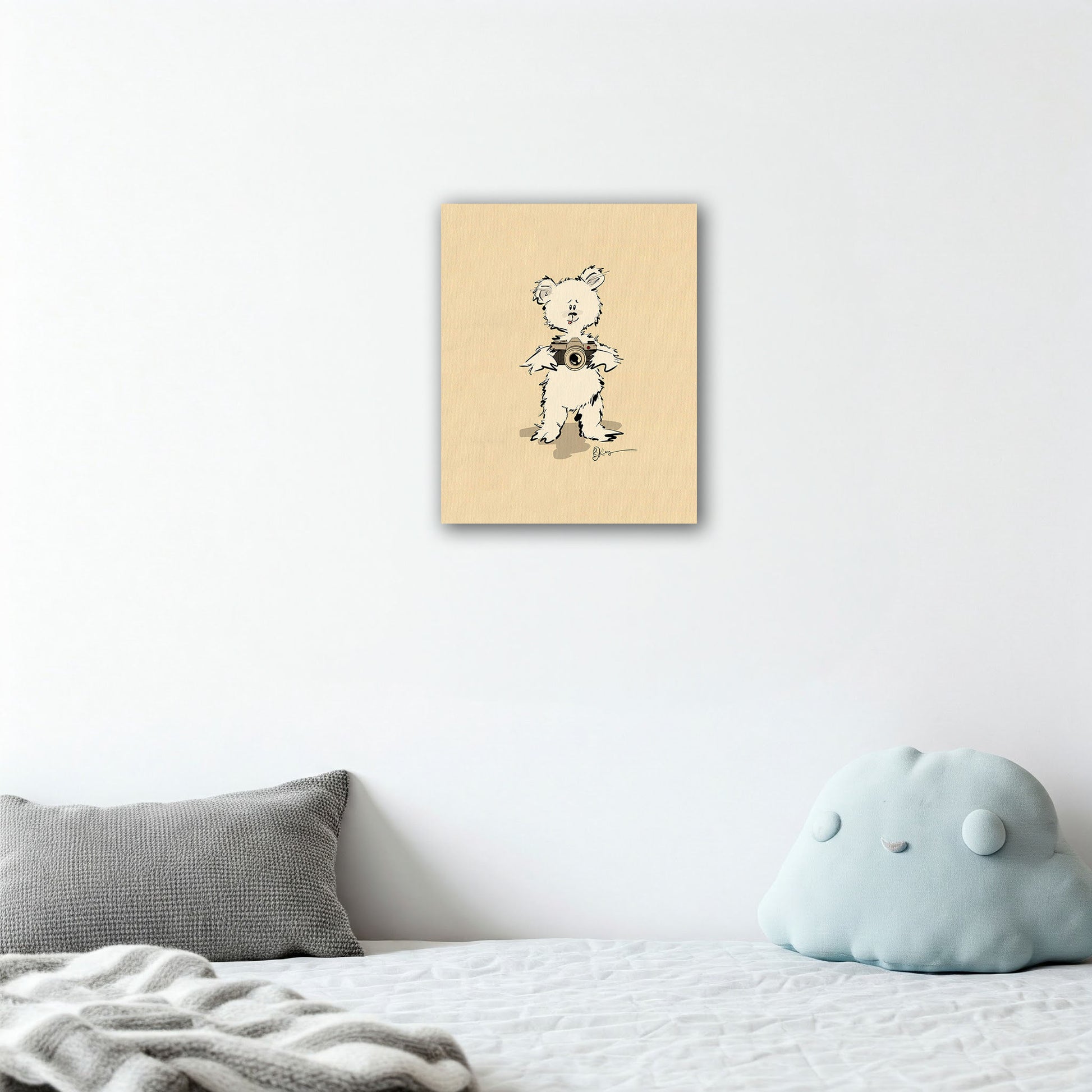 The Gopher Pola Bear print adds a touch of whimsical art to a serene and minimalist child's bedroom. The canvas is shown hanging above a bed with modern grey and light blue pillows."